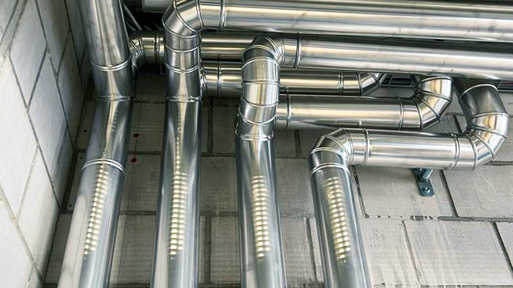 Polished metal cladding over insulated pipework – clean finish